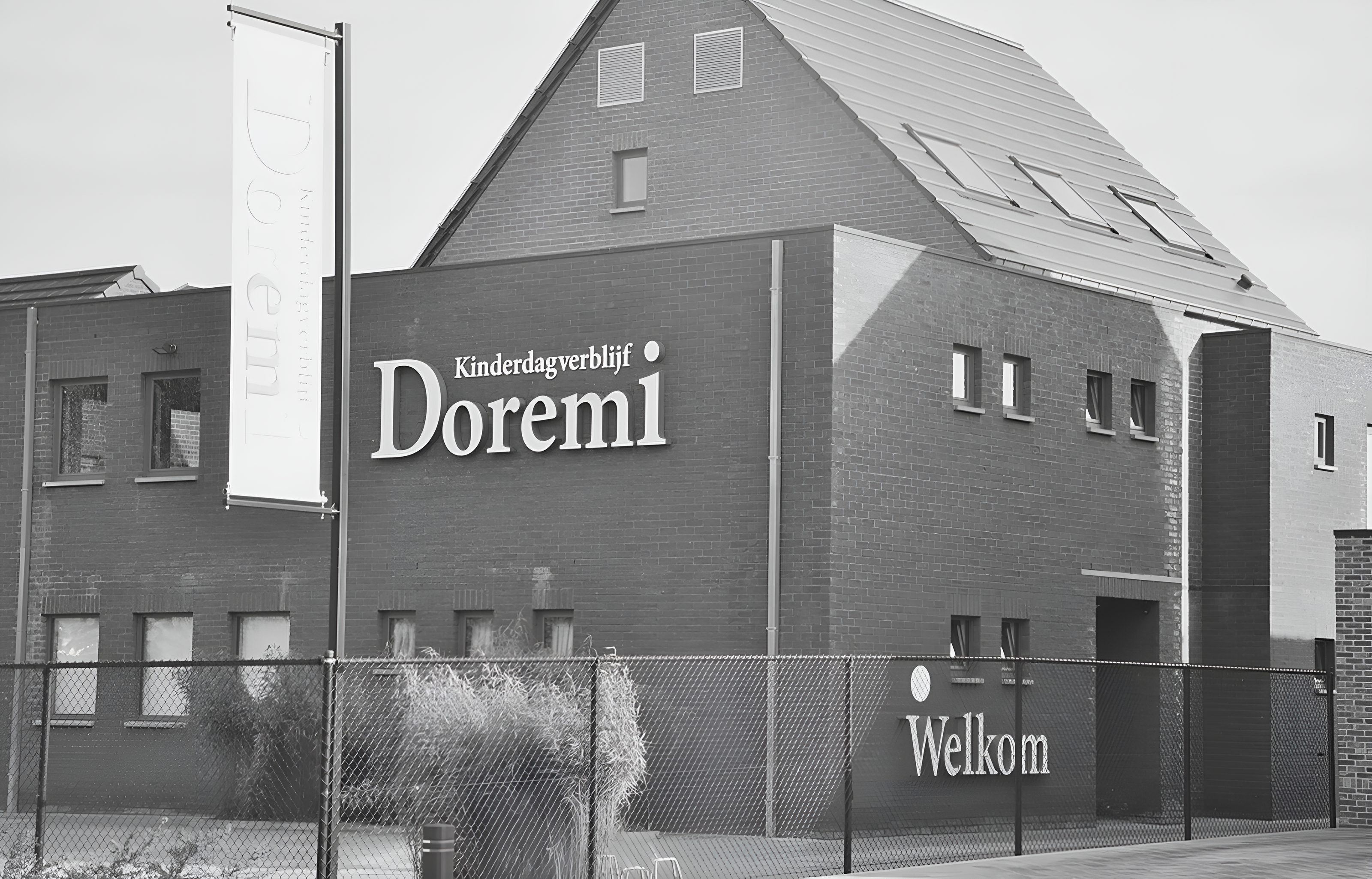De gevel van Kinderdagverblijf Doremi in de Meerlaarstraat in Laakdal, met de naamletters op de muur en Welkom aan de omheining